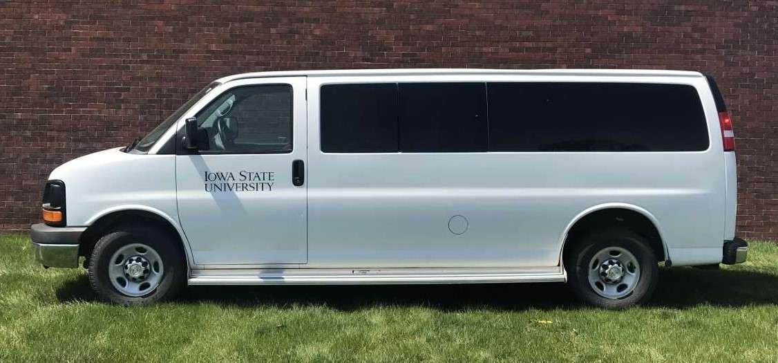 Large white van with Iowa State University written on side.
